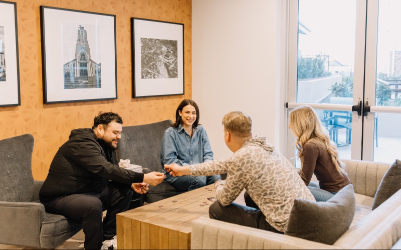 A group of friends playing a card game at The Harden at Public Market apartments in fort worth