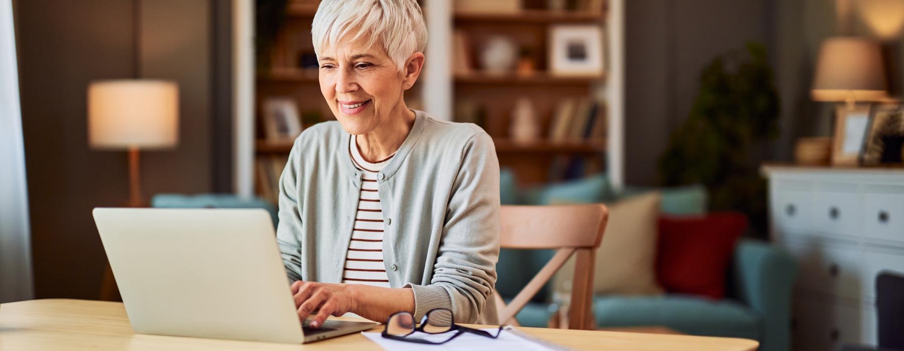 a person sitting at a table with a laptop